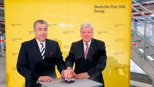 Jürgen Gerdes, Konzernvorstand Post - eCommerce - Parcel, (links) und der Hessische Ministerpräsident Volker Bouffier geben den Start frei für das größte Paketzentrum Deutschlands. Foto: DHL
