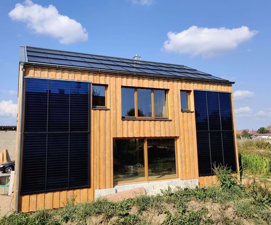 Bei dem Strohballen-Sonnenhaus von Familie Klotzbach erzeugen Photovoltaik-Module auf dem Dach Strom und Solarkollektoren an der Fassade Wärme. (Foto: Kai Klotzbach)